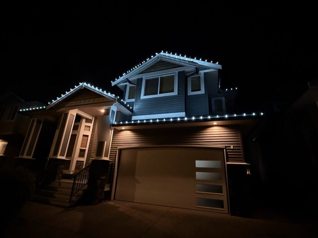Christmas lights along every roofline of a two-storey house at night, installed by Cleany X