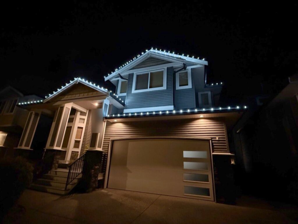 Christmas lights along every roofline of a two-storey house at night, installed by Cleany X