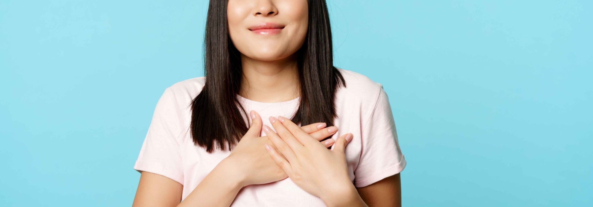 smiling-korean-woman-dreaming-holding-hands-heart-close-eyes-cherish-memory-her-soul-standing-blue-background